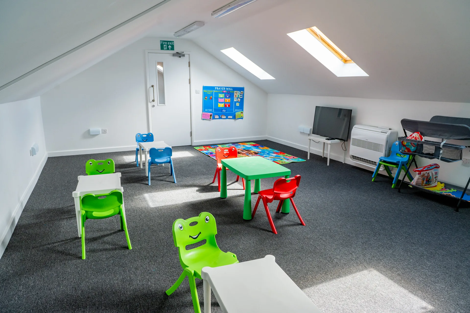 An empty room prepared with colourful tables and chairs for children