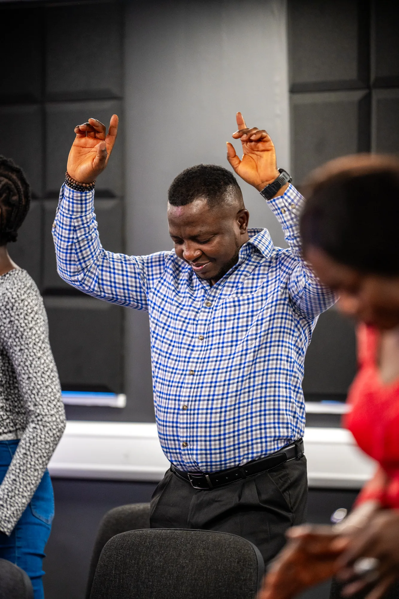 A congregation member with his hands raised during worship